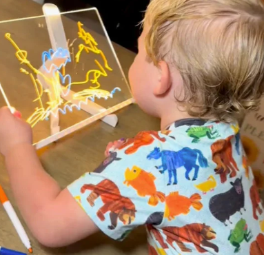 enfant qui joue et dessine avec la tablette lumineuse inspirée de la méthode montessori